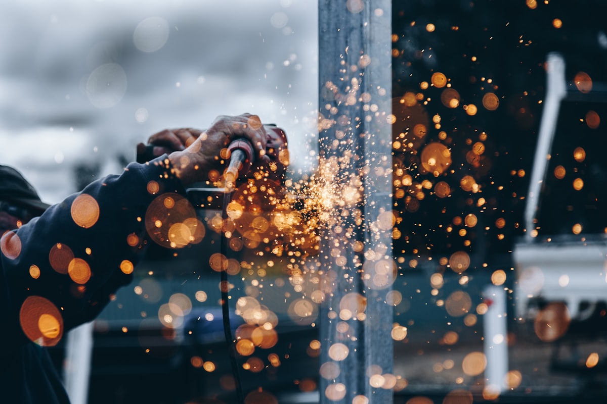 Worker grinding metal on a manufacturing shop floor